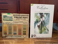 Photo showing two items: a mounted poster about an art exhibition and a metal Brandram-Henderson paint sign with color samples