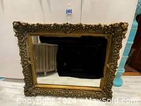 Front view of the large ornate vintage mirror with heavy carved gold-toned frame