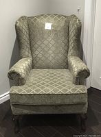Front view of the moss green Brentwood Classics armchair showing diamond patterned upholstery, wingback design, rolled arms, and carved wooden legs.