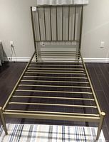 Full view of the gold metal twin bedframe showing the frame with metal slats and headboard.
