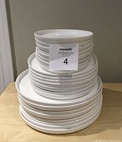 Stacked white Mikasa Alyssa china plates showing various sizes.