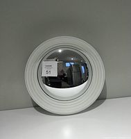 Front view of the white framed convex fisheye mirror showing the reflective surface and layered white frame on a plain background.