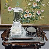 Overall view of the Krups blender and electric grill placed on a wooden surface, showing controls and cords.