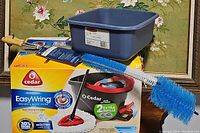 Photo showing O-Cedar EasyWring mop bucket, mop handle with microfiber mop head, and packaging box with branding.