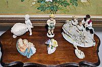 Overview of all six porcelain decorative pieces on wooden table.