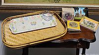 Bamboo trays with a rectangular pink floral ceramic tray and small clear plastic dish on the tray along with sets of coasters