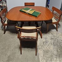 Five piece dining set with oval wooden table and four chairs, shown from front angle.