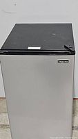 Front view of the Magic Chef compact refrigerator showing stainless steel door and black top.