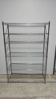 Front view showing five shelves of metal wire rack against a plain background.