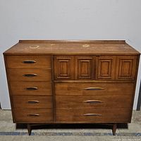 Front view showing full dresser with eight drawers and surface wear.