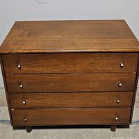 Front view of four-drawer chest showing overall design and drawer pulls