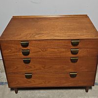 Front view of four-drawer chest showing overall appearance and brass half-moon pulls