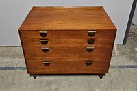 Front elevation of four-drawer wood veneer chest with brass-tone cup pulls