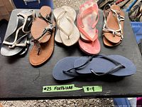 Six pairs of women's footwear sized approximately 8-9 with various designs and colors shown on a black surface.