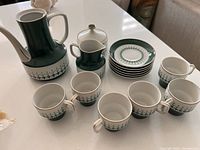 Full set including teapot, sugar bowl, milker, six espresso cups, and six saucers displayed on white surface.