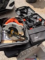 Photo showing a Black & Decker circular saw and cordless power drill in a black case along with an AllMAN Instant Tire Repair pouch.