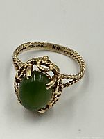 Ring front view showing oval green nephrite jade cabochon in 14k gold setting