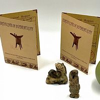 Close-up image of two jade carvings with certificates behind them, clearly showing details and condition.