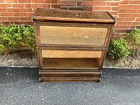 Front view of one barrister bookcase unit showing wood grain, glass door and bottom drawer.