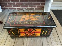 Front and top view of painted chest showing ship motif and decorative borders