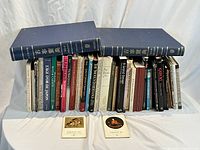 Front view of all 43 books arranged in two rows, showing various colors and sizes, including two large blue volumes on top