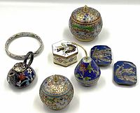 Full set of cloisonné miniatures arranged on white background: three lidded boxes, hinged bangle, small teapot, two belt buckles