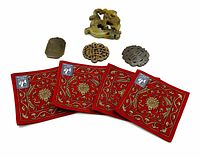 Group shot of four jade carvings and four red fabric coasters on white background