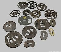 Overview of all 16 tsuba laid out on white background