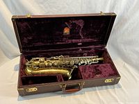 Tenor saxophone in open hard case lined with purple velvet