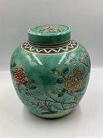Front view of ginger jar with lid on, showing overall shape and main floral and bird decoration.