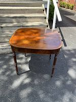 Full view of table from front showing overall shape, legs, and finish