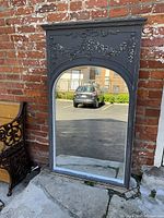 Overall front view of mirror leaning against brick wall