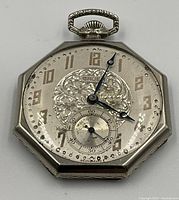 Front view of octagonal pocket watch showing Art Deco dial, Arabic numerals, blue-steel hands and small seconds subdial