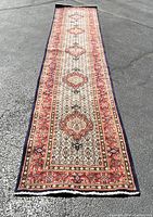 Full-length view of runner rug on asphalt