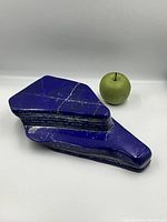Stone and green apple for scale, displaying overall shape and size.