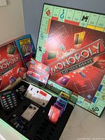 Monopoly Electronic Banking board game box and open box showing electronic banking unit and game cards.