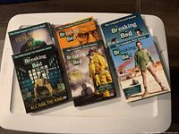Photo showing all six DVD sets for Breaking Bad seasons 1 through 5 plus The Final Season special, laid out on a flat white surface.