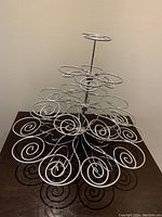 Front angled view of the metal cupcake stand showing spiral holders and three-tier structure.