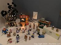 Wide shot showing the full set including two buildings, multiple figurines, and village accessories arranged on table.
