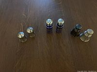 Photo showing three pairs of salt and pepper shakers arranged on a wood surface.