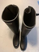Top view of the pair of black tall Hunter boots showing inside and upper trim.