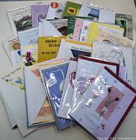 Wide view of unopened, assorted greeting cards with various themes and envelopes included.
