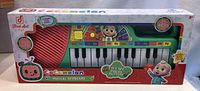 Photo of the Cocomelon Musical Keyboard unopened in its original packaging, showing colorful design, keys, and branding details