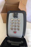 Front view of the key lock box with keypad visible and cover open.