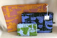 Three Baggu zippered pouches with mushroom pattern, arranged in size order and showing brand tag on the medium pouch.
