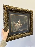 Side angled view of the antique carved gold wood frame holding the "Lady of Shalott" print.