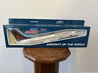 Front view of unopened boxed model airplane showing Air Canada livery inside Sky Marks packaging