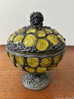 Side angle view showing yellow art glass embedded in textured cast iron framework with leaf and vine designs.