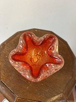 Top-down view showing the star-shaped opening and fiery red-orange central glass within clear surrounding glass with air bubbles.