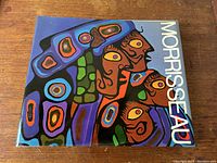Front cover of the hardcover book showing colorful Inuit art faces and title Morrisseau.